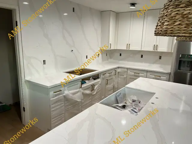 White kitchen with veined white countertops and a matching full-height stone backsplash